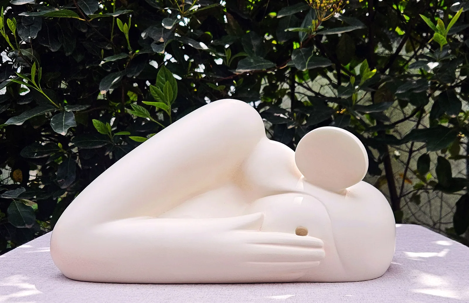 Hiding — a curled-up cream figure tucking its head behind its arm, cast polyester sculpture