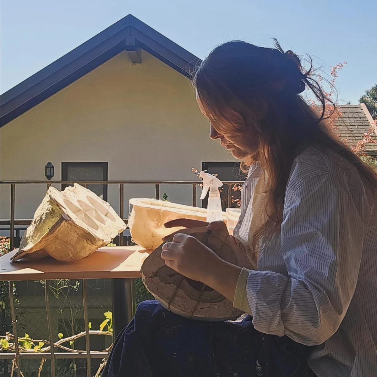 Sibel Açıkalın Akgün working on a sculpture mould outdoors in her studio